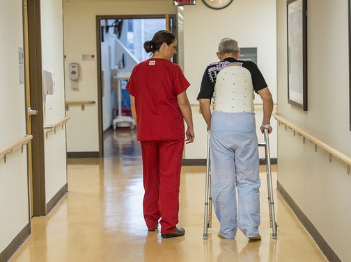 Healthcare worker with an elderly man using a walker