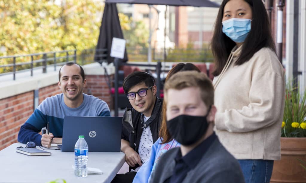 Moses Hsieh (center) converses with peers outside Professor Falletta's class. (Courtesy: Deirdre Flanagan)