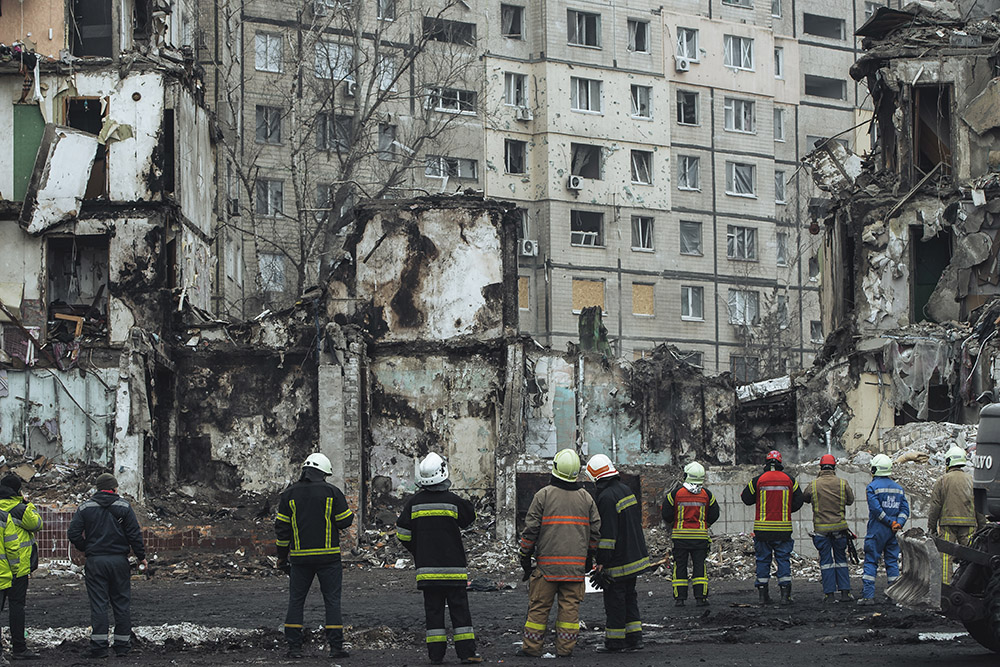 Photo of Dnipro Ukraine with firefighters looking at a burned out building
