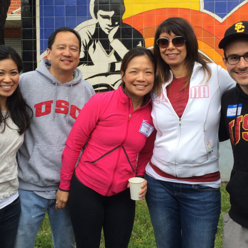 Five USC Price alumni wearing USC gear at the Alumni Day of Service event