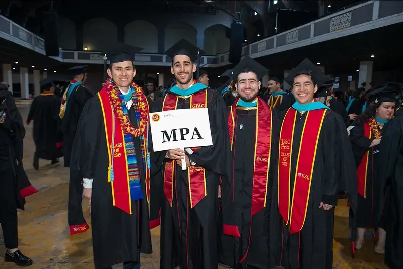 Master of Public Administration students at graduation holding up an MPA program sign