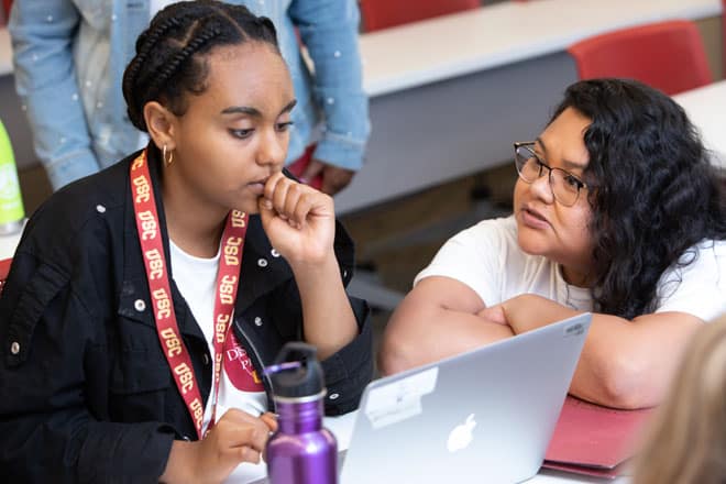USC Rossier student Erika Mejia (right) helps guide students through computer work during The Discovery Project in the summer of 2019. (Courtesy: Brian Morri)