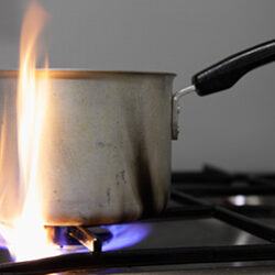 small pot being used to cook on a gas stove with a very high flame