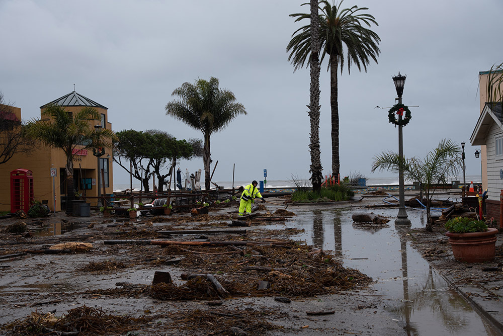 Person cleans up debris after California storm.