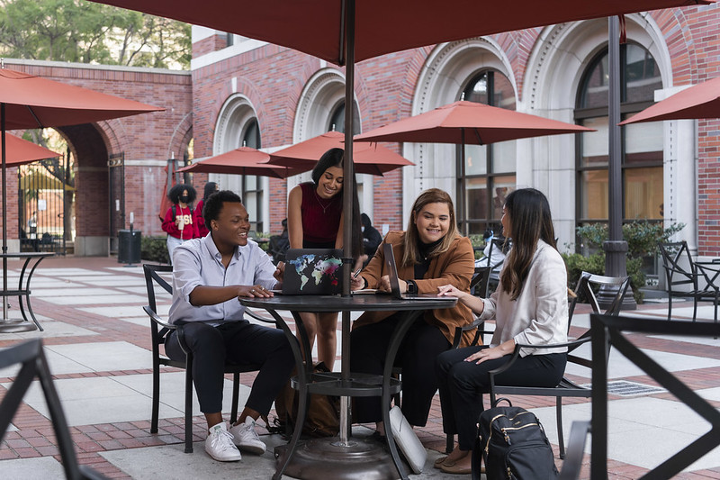 USC Price students sitting at tables on campus.