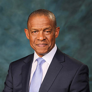 Headshot of Erroll Southers wearing a dark blue suit and tie