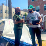 Homelessness outreach workers standing in front of a tent