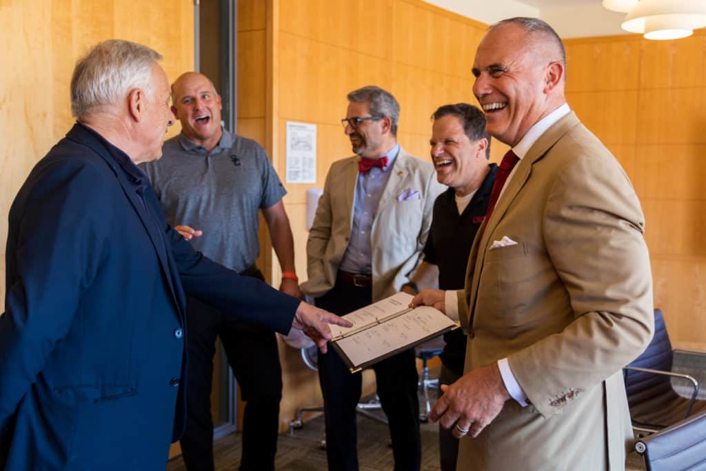 Deans from Viterbi and Price laugh together after MOU signing