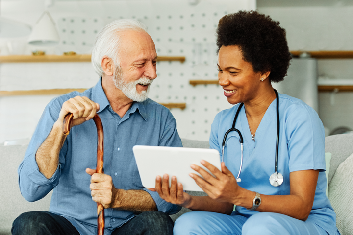 Doctor talks to patient and uses a tablet computer.