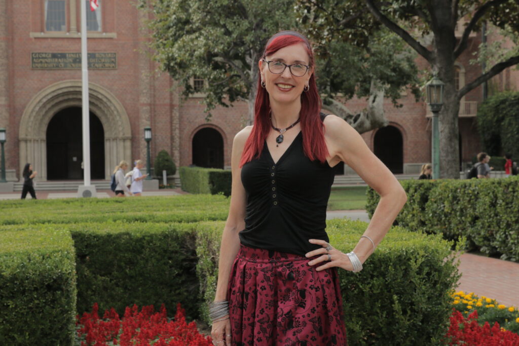 Wandi Bruine de Bruin stands in front of a garden at the USC campus