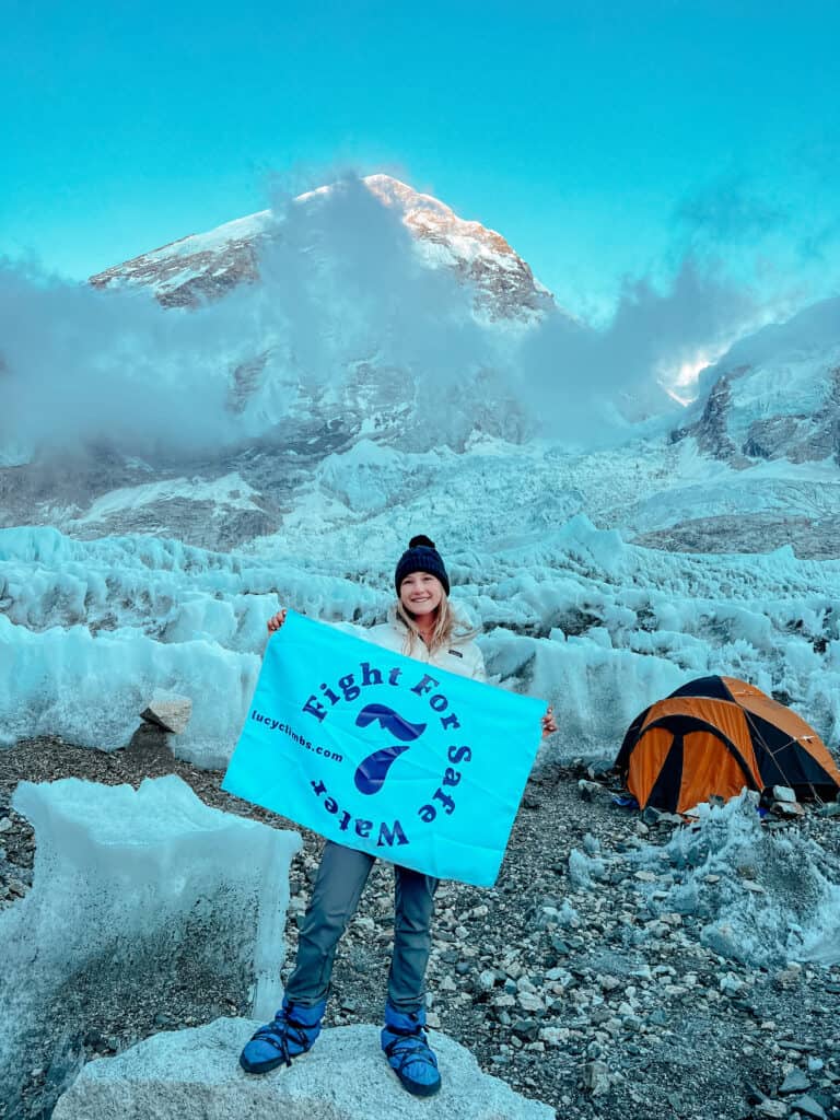 Westlake holds a sign reading "Fight for Safe Water at Everest Camp 