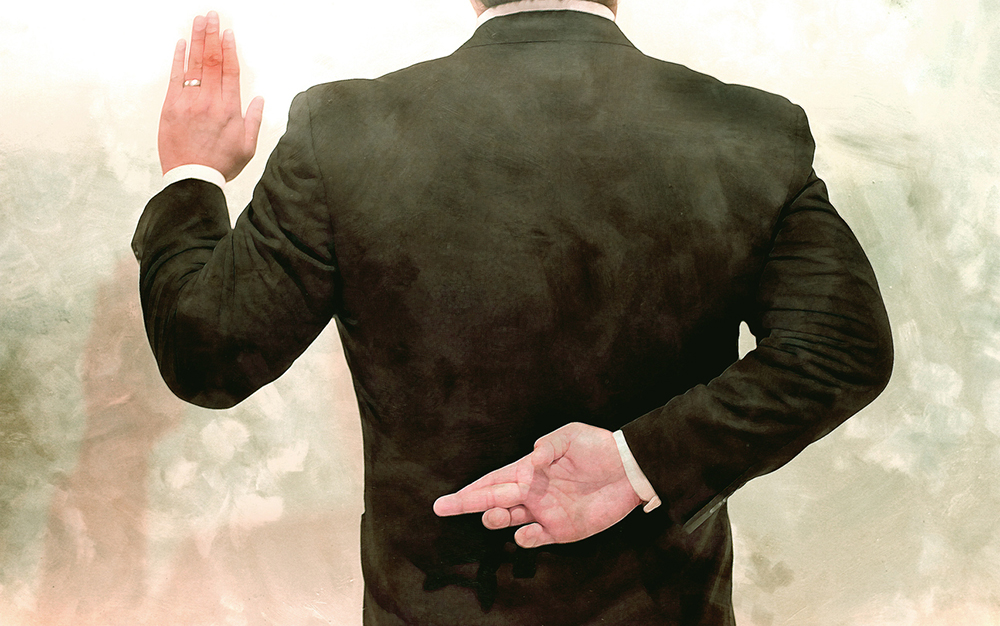 A man in a suit crosses his fingers behind his back while raising his other hand to take an oath