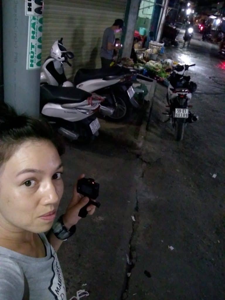 Huê-Tâm Jamme in Ho Chi Minh City pointing at motorized bicycles