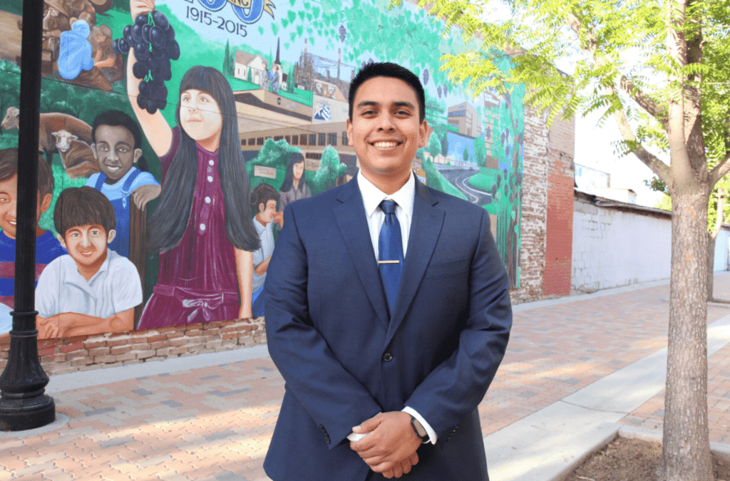 Bryan Osorio in front of street mural