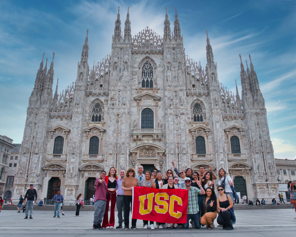 Students abroad holding a USC banner.