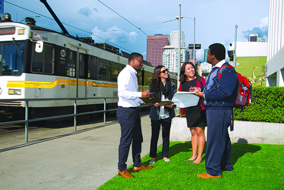 Master of Urban Planning students talking in front of the Los Angeles Metro Rail.