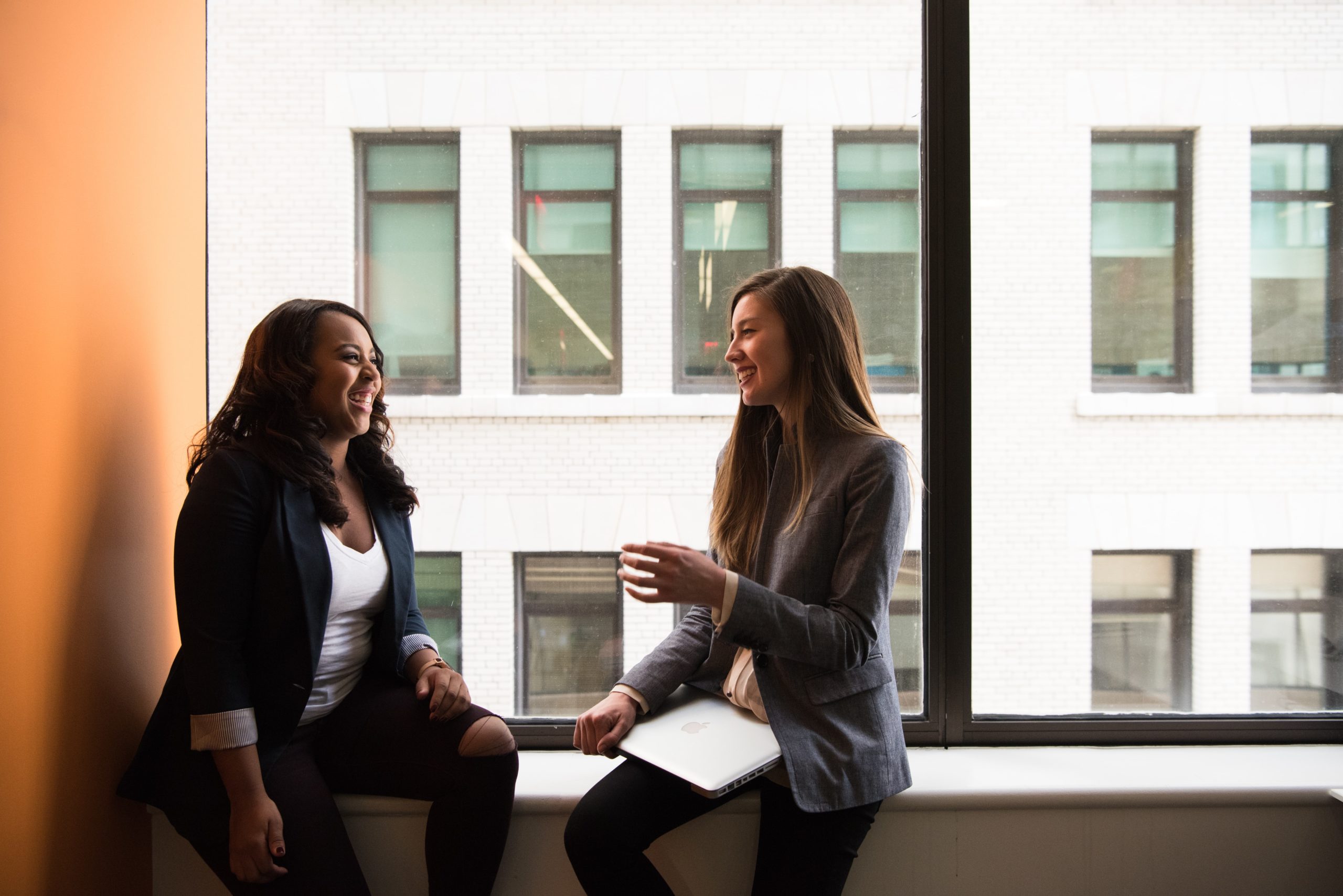 Two women talking in a classroom.