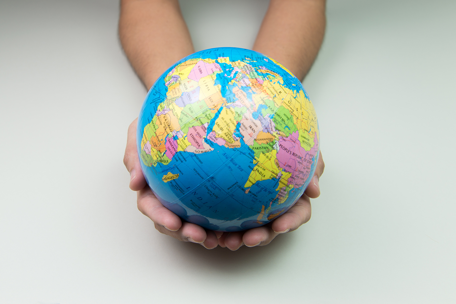 Earth globe in hand over white background