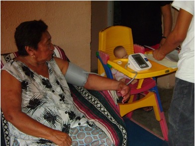 Older latina woman receiving medical attention in her home.