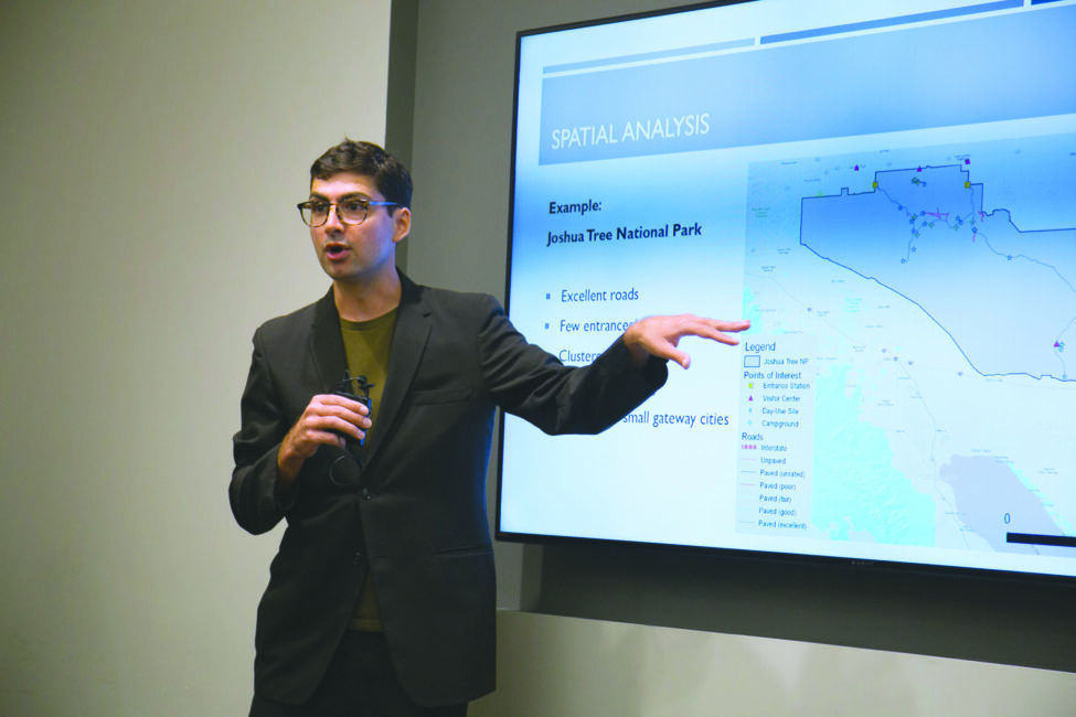 A Master of Public Policy Data Science student presenting a map with data points in front of the classroom.