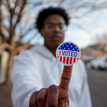 Man Holding an I Voted Sticker Up to the Camera