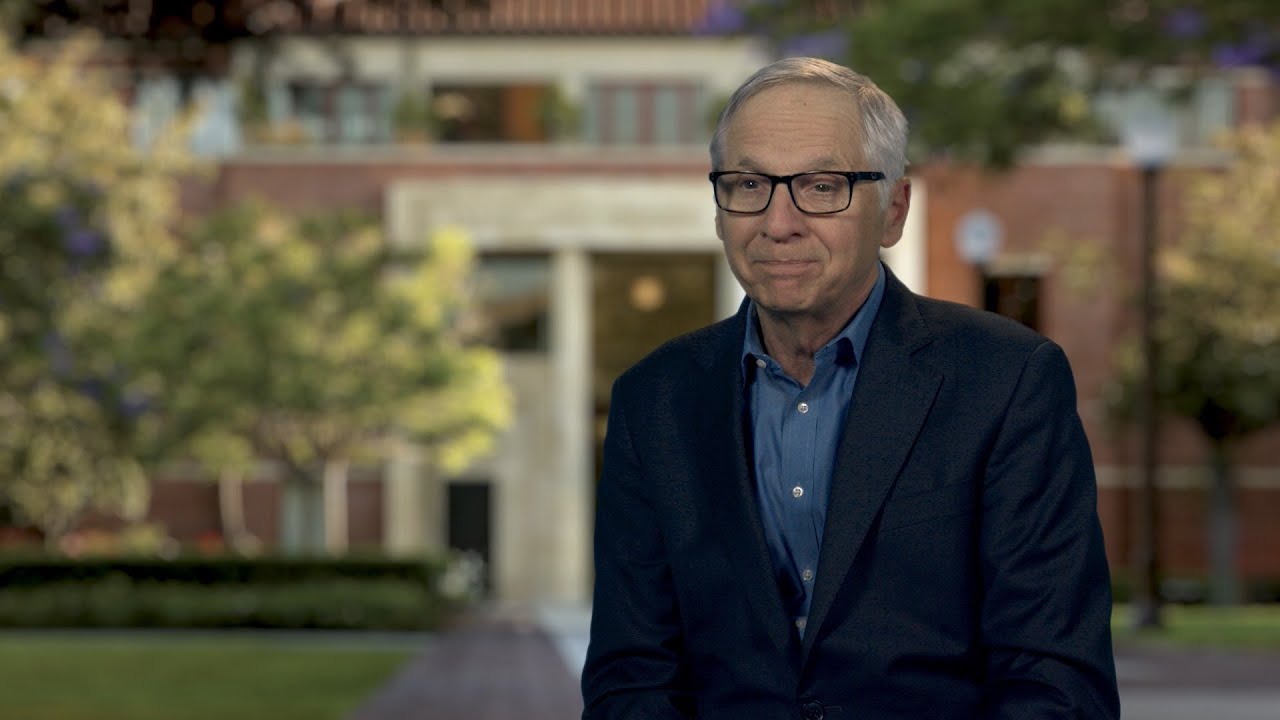 Mark Baldassare talks in front of an image of USC campus