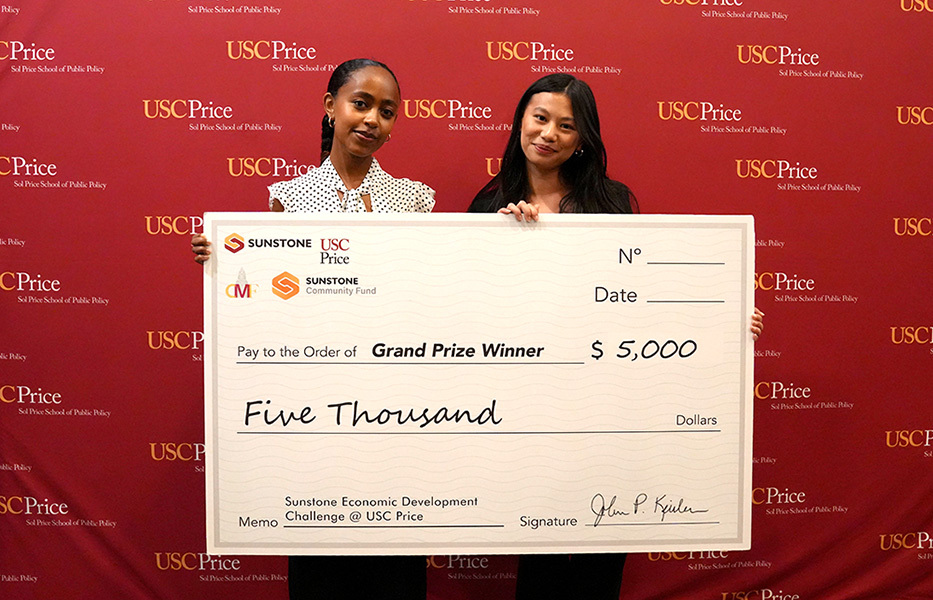 Winners Rediet Retta and Sydnee Yu hold a giant check for $5,000.