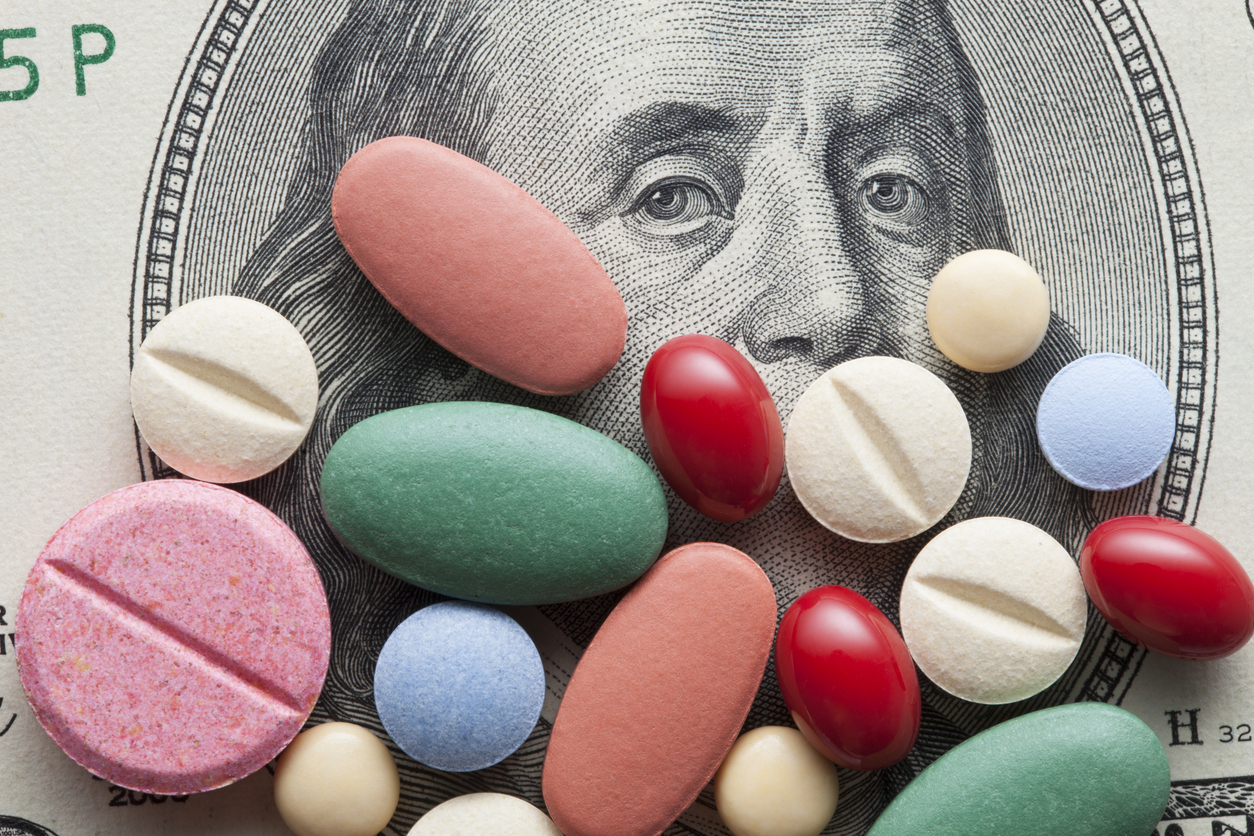 Medicine pills on top of a $100 bill