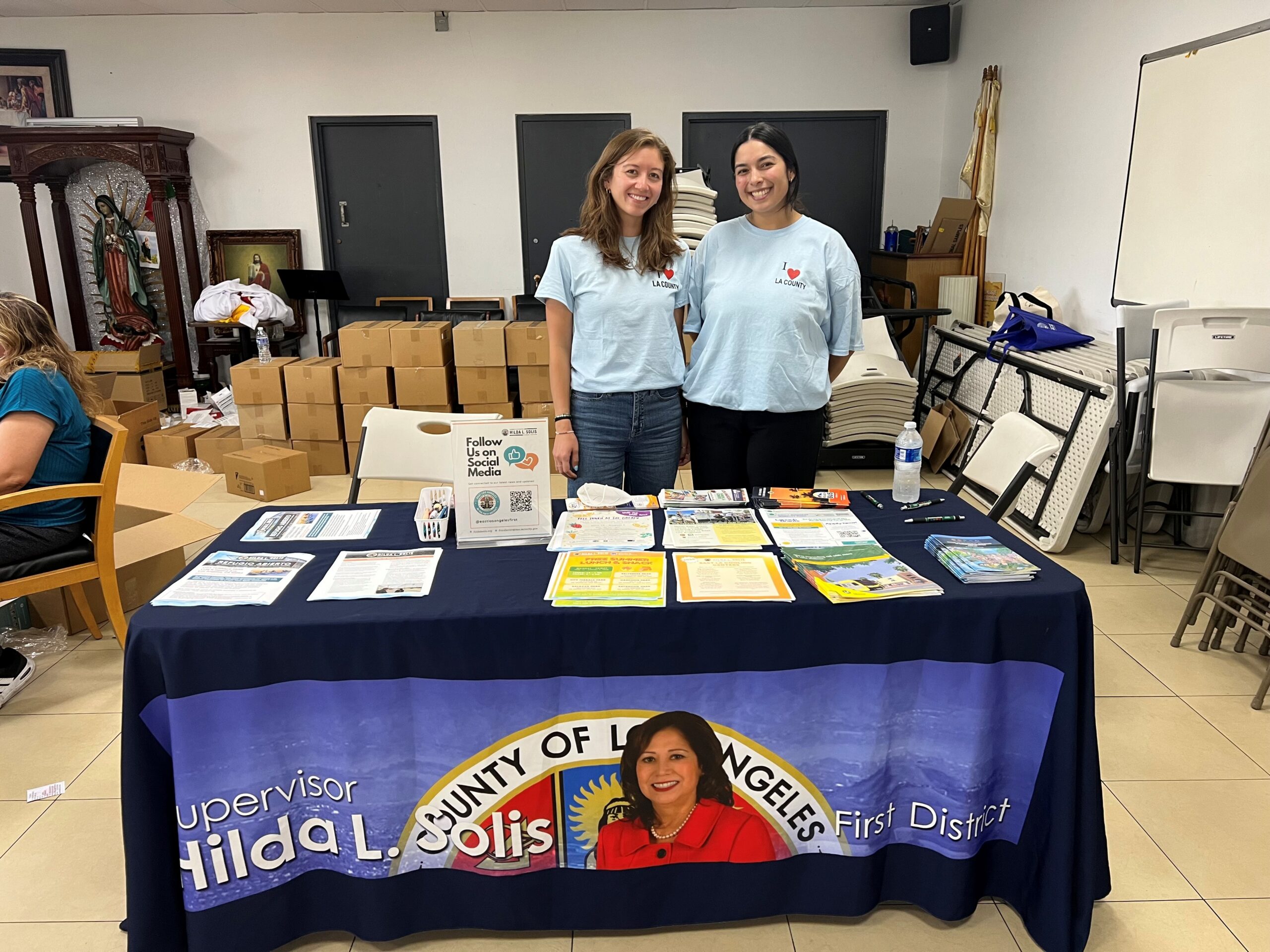 Erin Lopez and Emily Desmond sharing Los Angeles County resources and programs available for impacted residents. (Our Lady of Victoria Church, East Los Angeles. June 23, 2026)